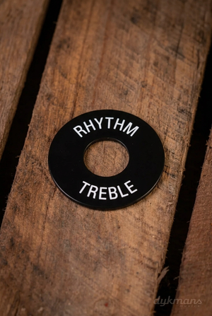 Gibson PRWA-020 zwart schakelaarplaatje met witte RHYTHM- en TREBLE-opdruk op een houten ondergrond